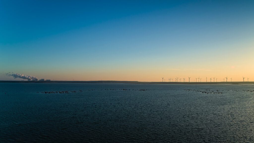 Sonnenaufgang am Cotttbuser Ostsee vom Aussichtsturm Merzdorf aus gesehen / Blickrichtung Nord-Ost / links Braunkohlekraftwerk Jänschwalde, rechts Windpark Cottbus (AR 10/2024)