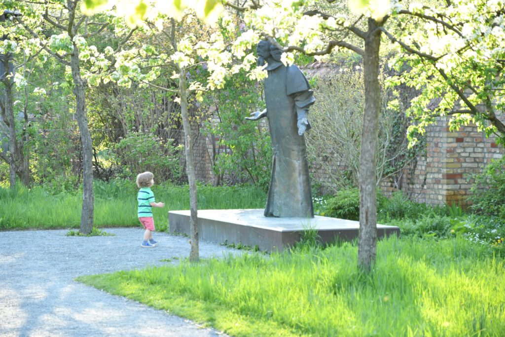 Ein Kind im Dialog mit der Skulptur des Universalgelehrten Comenius im Comenius-Garten in der Richardstraße (Das Neukölln-Porträt / AR 04/2018)