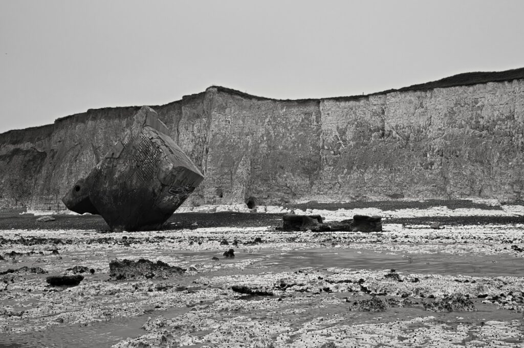 Senkrecht im Kiesstrand stehender Atlantikwall-Bunker in Sainte-Marguerite-sur-Mer