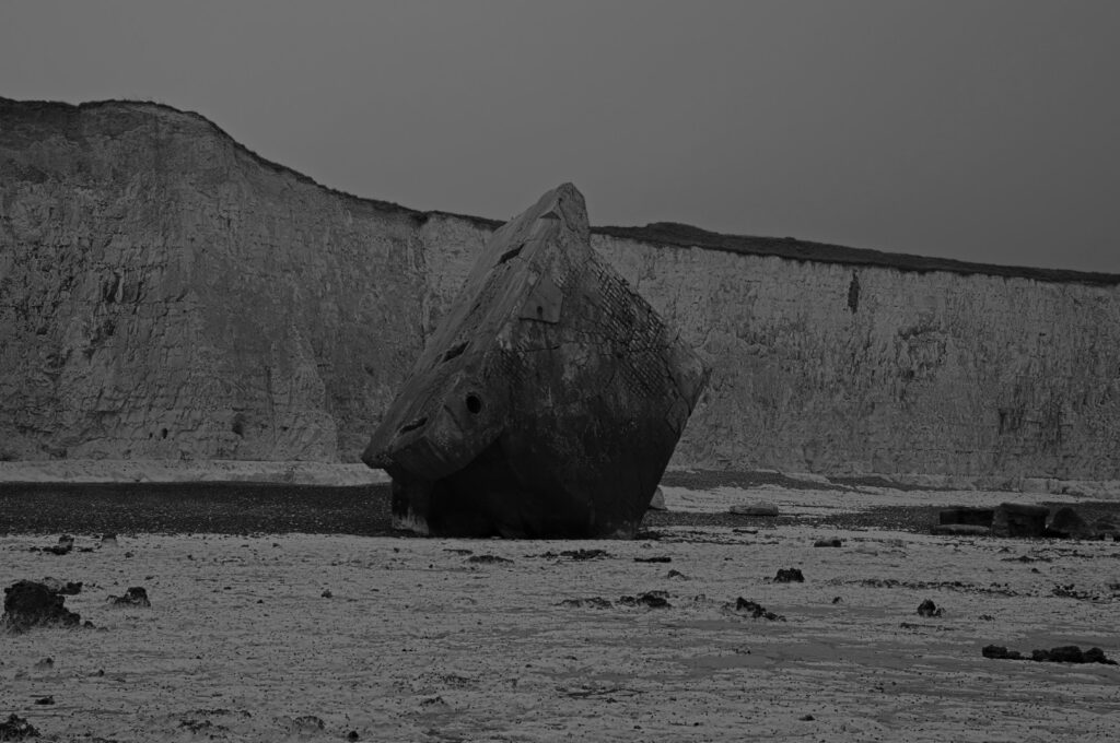 Senkrecht im Kiesstrand stehender Atlantikwall-Bunker in Sainte-Marguerite-sur-Mer