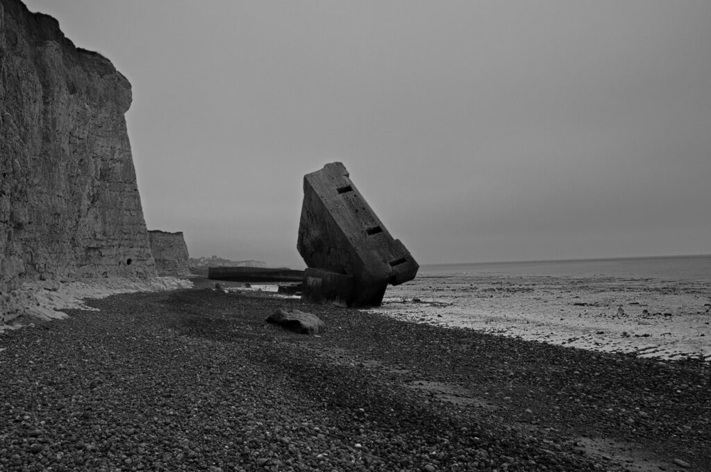 Senkrecht im Kiesstrand stehender Atlantikwall-Bunker in Sainte-Marguerite-sur-Mer