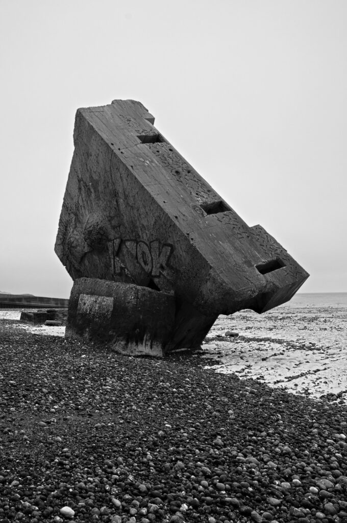 Senkrecht im Kiesstrand stehender Atlantikwall-Bunker in Sainte-Marguerite-sur-Mer