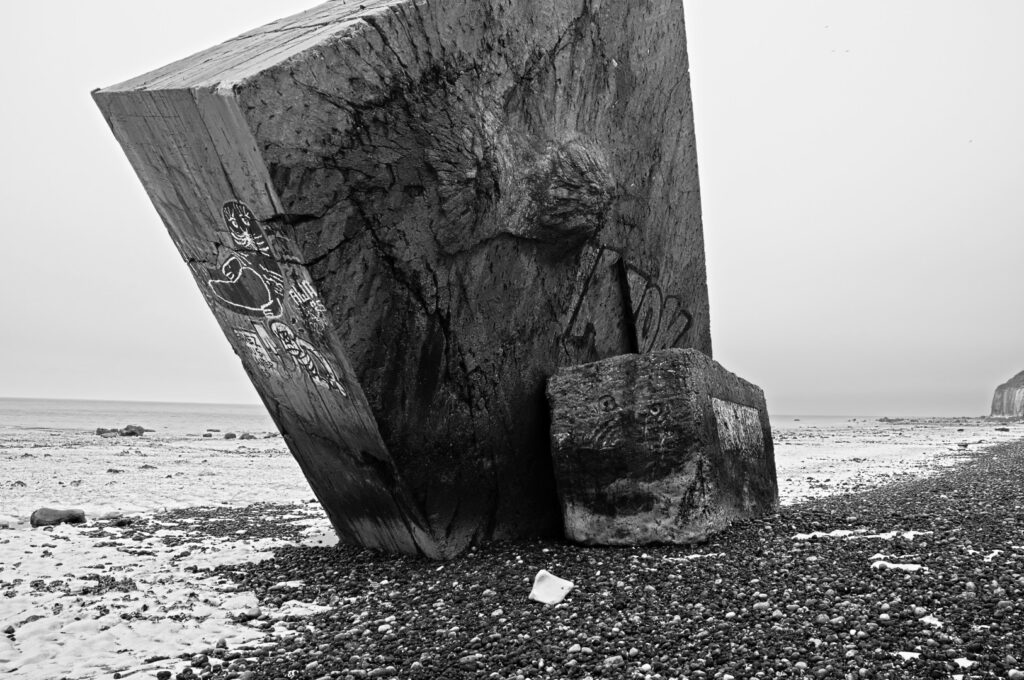 Senkrecht im Kiesstrand stehender Atlantikwall-Bunker in Sainte-Marguerite-sur-Mer