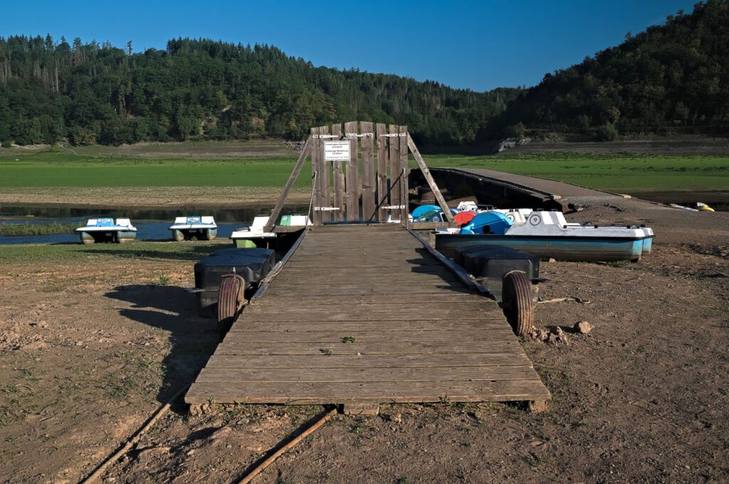retboote und Bootssteg liegen bei Niedrigwasser auf trockenem Speicherboden