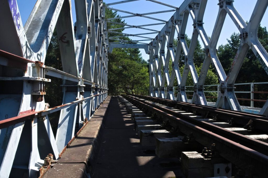 Rostige Schienen verlaufen durch das Stahlfachwerk der stillgelegten Klinkerhafenbrücke.