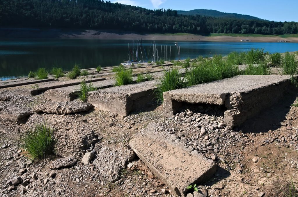 Freigelegte Gräber am Edersee bei Niedrigwasser 2026 mit Segelbooten im Hintergrund
