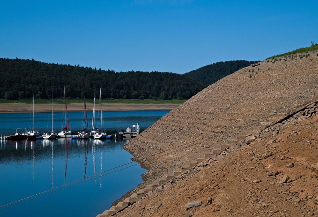 Segelboote am stark abgesunkenen Edersee neben einer weit freigelegten Uferböschung im Juli 2026